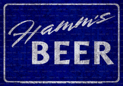 Vintage metal sign featuring the classic HAMM'S beer logo and branding with a distressed, weathered finish. The design includes bold colors and retro typography, evoking mid-century advertising. The sign has pre-drilled holes for easy hanging."